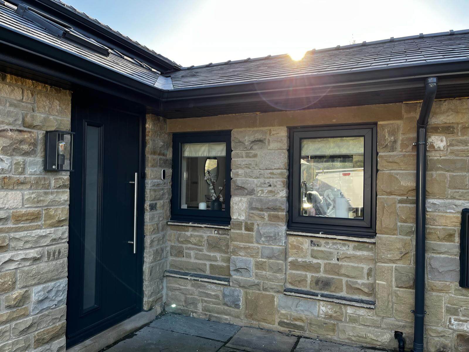Stone wall with black door and windows